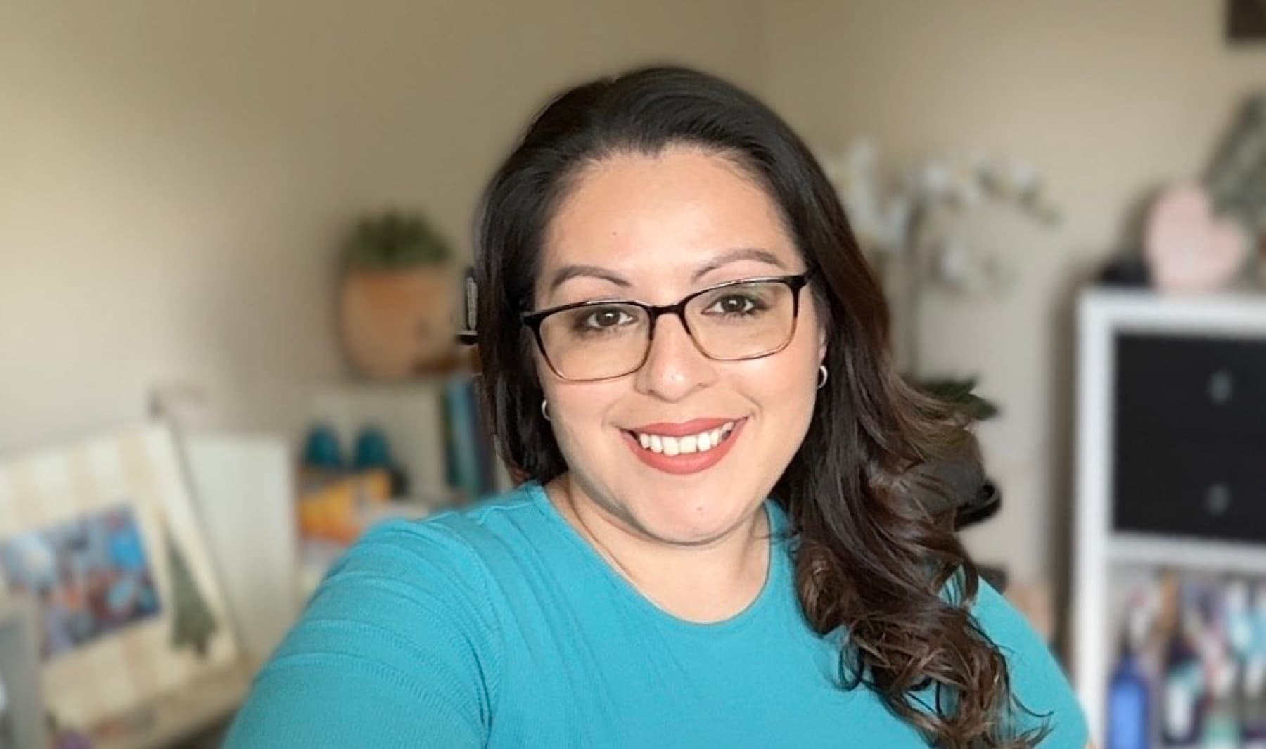 Becky Romero smiling in her Colorado home office