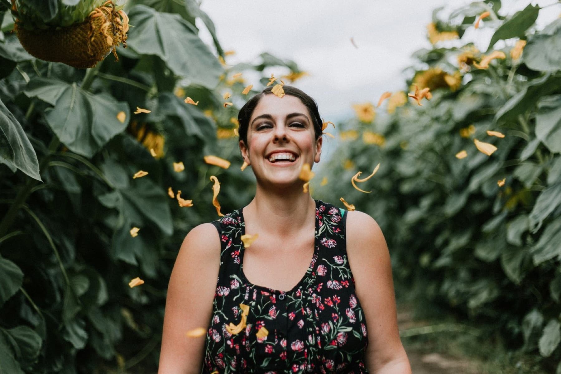 A woman laughing among sunflowers, feeling light and free