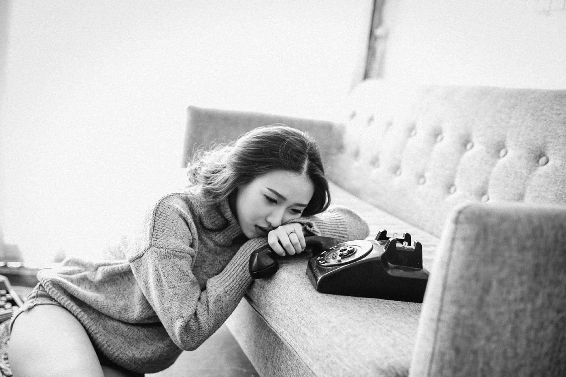 A woman resting her head on a couch, lost in thought